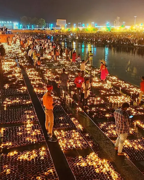 Volunteers walking between rows of lit lamps covering the river steps