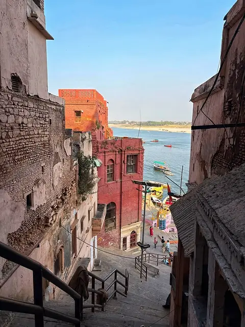 A narrow stone alley stepping down between old houses to the river